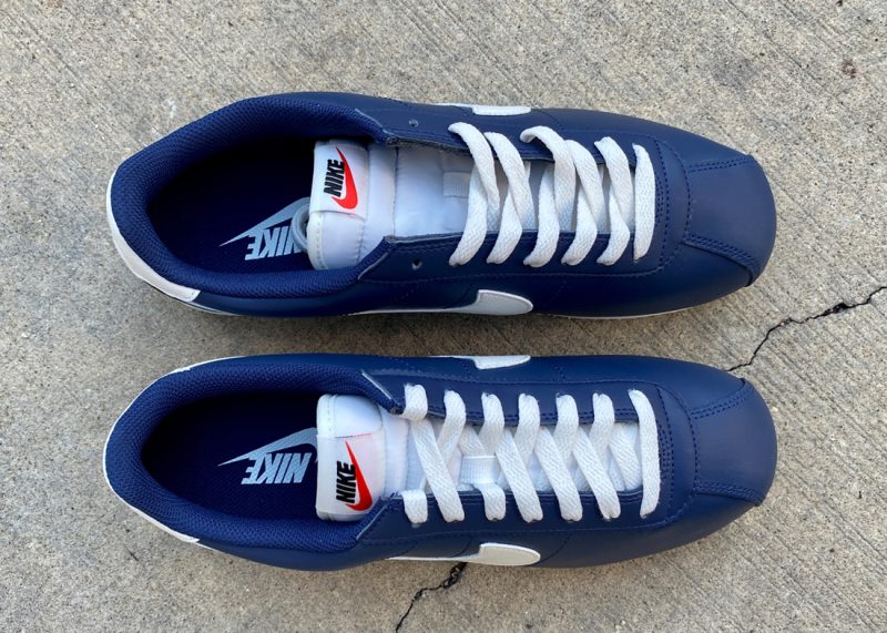 white and navy blue nike cortez